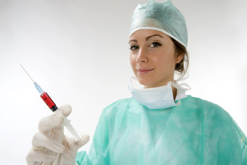 a young nurse in operation dress with a syringe full of blood