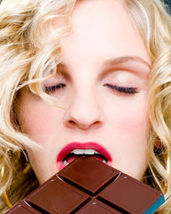 Blonde Frau geschlossenen Augen Schokolade auf Zunge zergehen