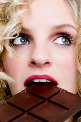 weibliches Gesicht mit blick nach oben beim essen von Schokolade
