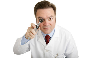 Closeup of a doctor peering into an otoscope 