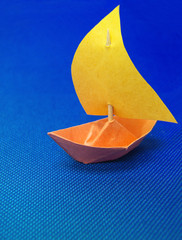 Close up of paper boat on blue background.