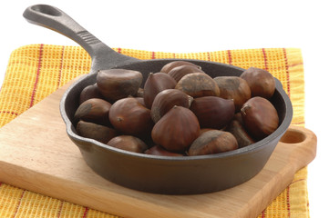 Cast iron pan filled with roasted chestnuts.
