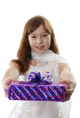 The girl in a white dress shows the christmas gift