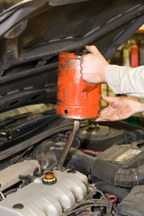 Mechanic refilling the pan during an automobile's oil change
