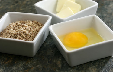 Raw eggs, butter and flour on a granite countertop