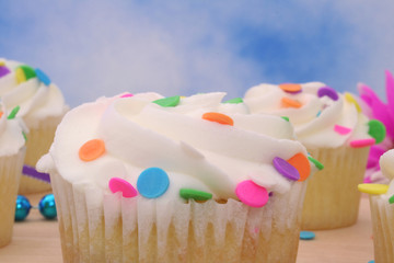 Cupcakes With Colorful Candy and Blue Sky Background