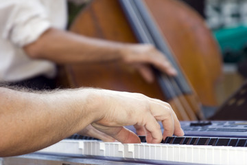 Mains du pianiste avec le contrebassiste en fond