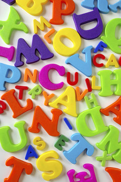 Composition of colorful plastic toy letters over white