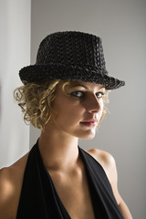 Caucasian woman wearing fedora hat looking at viewer.