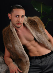 A handsome fashion model posing in a fur coat
