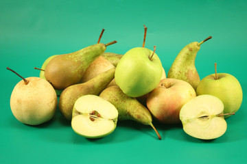 Apples and pears on a green background.