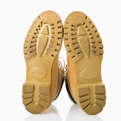 Pair of tan construction boots with sole facing viewer.