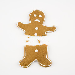 Frowning male gingerbread cookie broken in half.