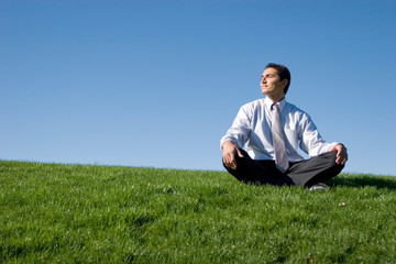 Naklejka na ściany i meble Biznesmen medytacji na zielonej trawie
