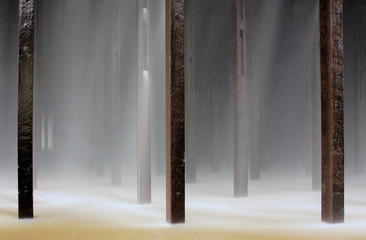 Water and poles underneath a cooling tower of a power plant
