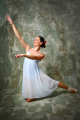 Ballerina kneeling down and raising hands.