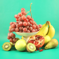 Different fruits on a green background.