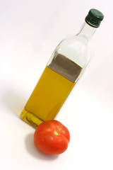 Fototapeta premium Olive oil in transparent bottle with one big tomato