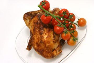 Whole fried chicken with many cherry tomato on branch on him
