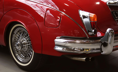 rear section of an old red jaguar coupe with a chrome bumper