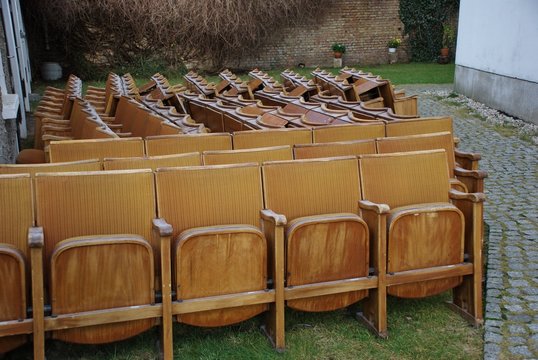 Some Old Defective Cinema Chairs In A Garden.