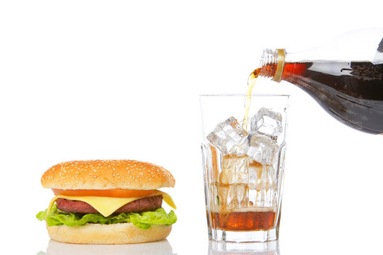 Cheeseburger and glass of soda, reflected on white background