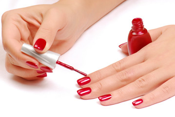 Woman brushing her nails in the red color