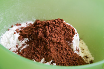 Mixing flour and cocoa in green bowl