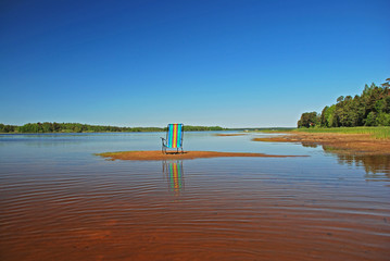 One empthy colourful beach chair in the water