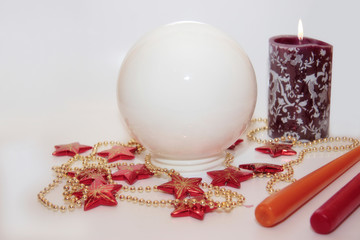 christmas crystal ball against a bright background with candles