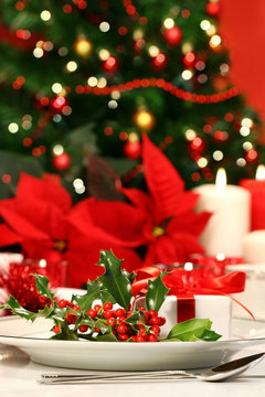 Festive holiday table with holly and poinsettias
