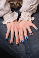 A pair of hamds with a painted in blue nails