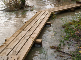 Wooden bridge through flooded river, close-up