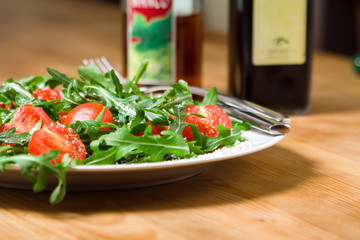 italian salad with rucola, tomatoes, parmesan, oil, vinegar