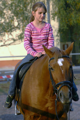 fr&ouml;hliches M&auml;dchen beim Reiten