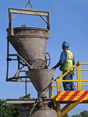 Worker pours cement into the well, close-up