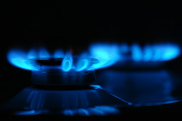 Two gas cooker burners lit in the darkness