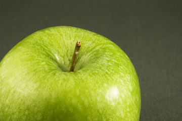 Gros plan sur une pomme verte isolée sur fond sombre