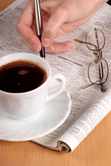 Coffee cup with glasses and newspaper