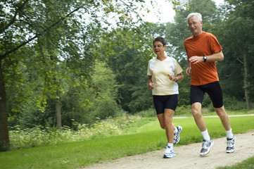 Senior couple running through the woods. Some motion blur.