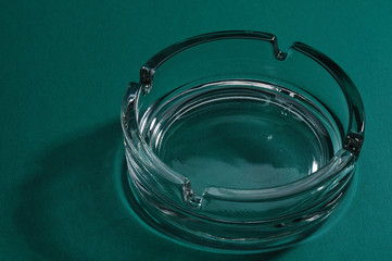 Glass ashtray without cigarette on the green table. - 5432816