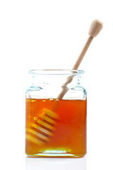 Drizzler inside of honey jar, reflected on white background.