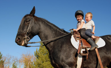 two happy children on their black stallion..