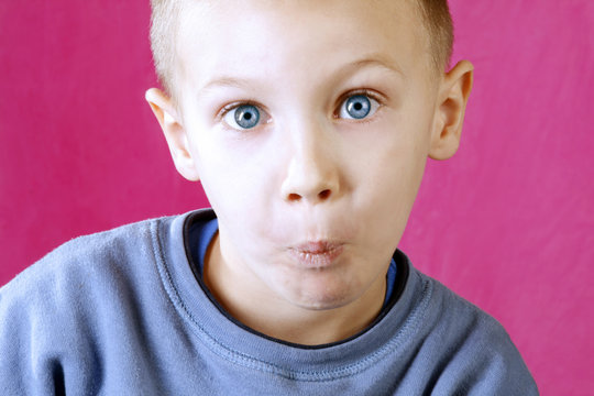 little boy with blue eyes confused