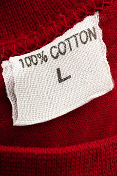 a t-shirt tag with 100% cotton writen on it