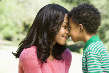 Obraz premium Mother and young son with heads together smiling.