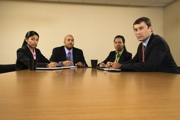 Businesspeople sitting at conference table.