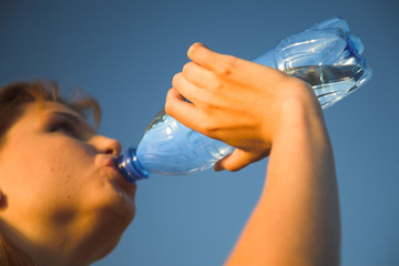 young girl with bottle against blue sky