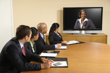 Businesspeople in conference looking at display.
