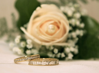Two golden rings over wedding boquet